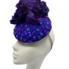 Stunning purple felt base headpiece with irridescent blue embelished detail and finished with stunning hand made silk flower details.